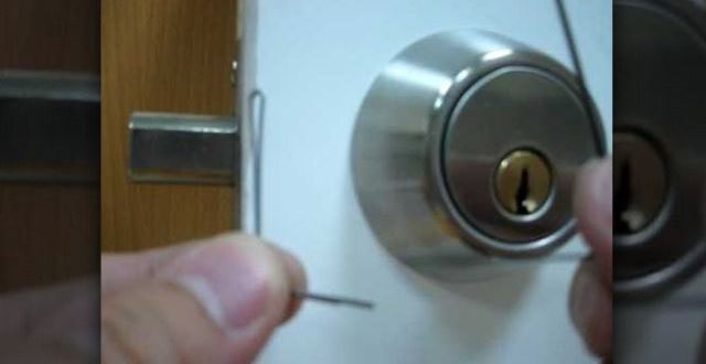 A person unlocking A Deadbolt Lock With Bobby Pin