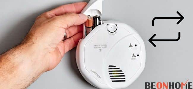 A person replacing smoke detector battery