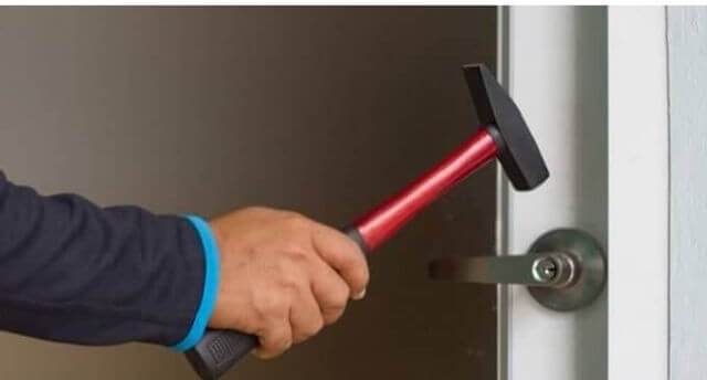 A person Breaking a Lock With A Hammer 